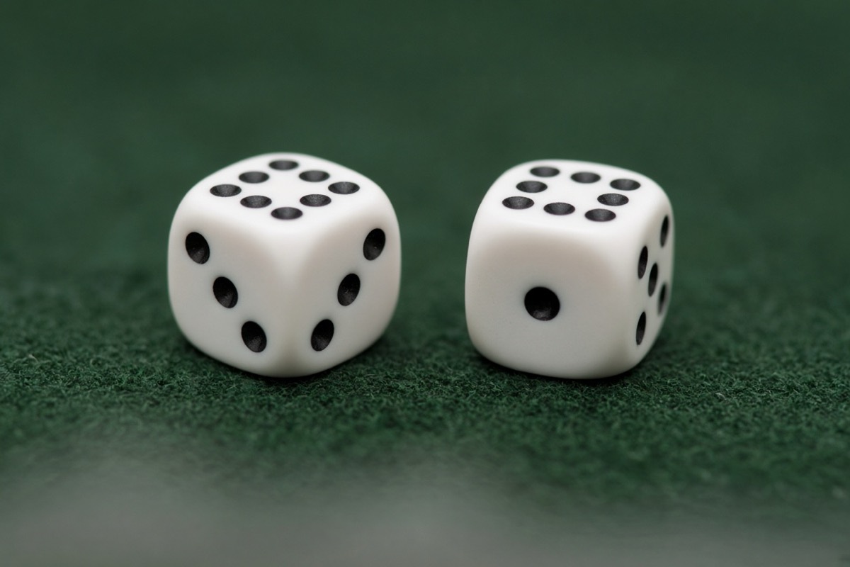 How to play craps for beginners: two white dice on green felt, illustrating a craps roll.